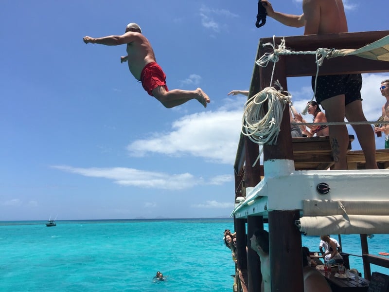 View photo of a guest jumping from a boat into the sea